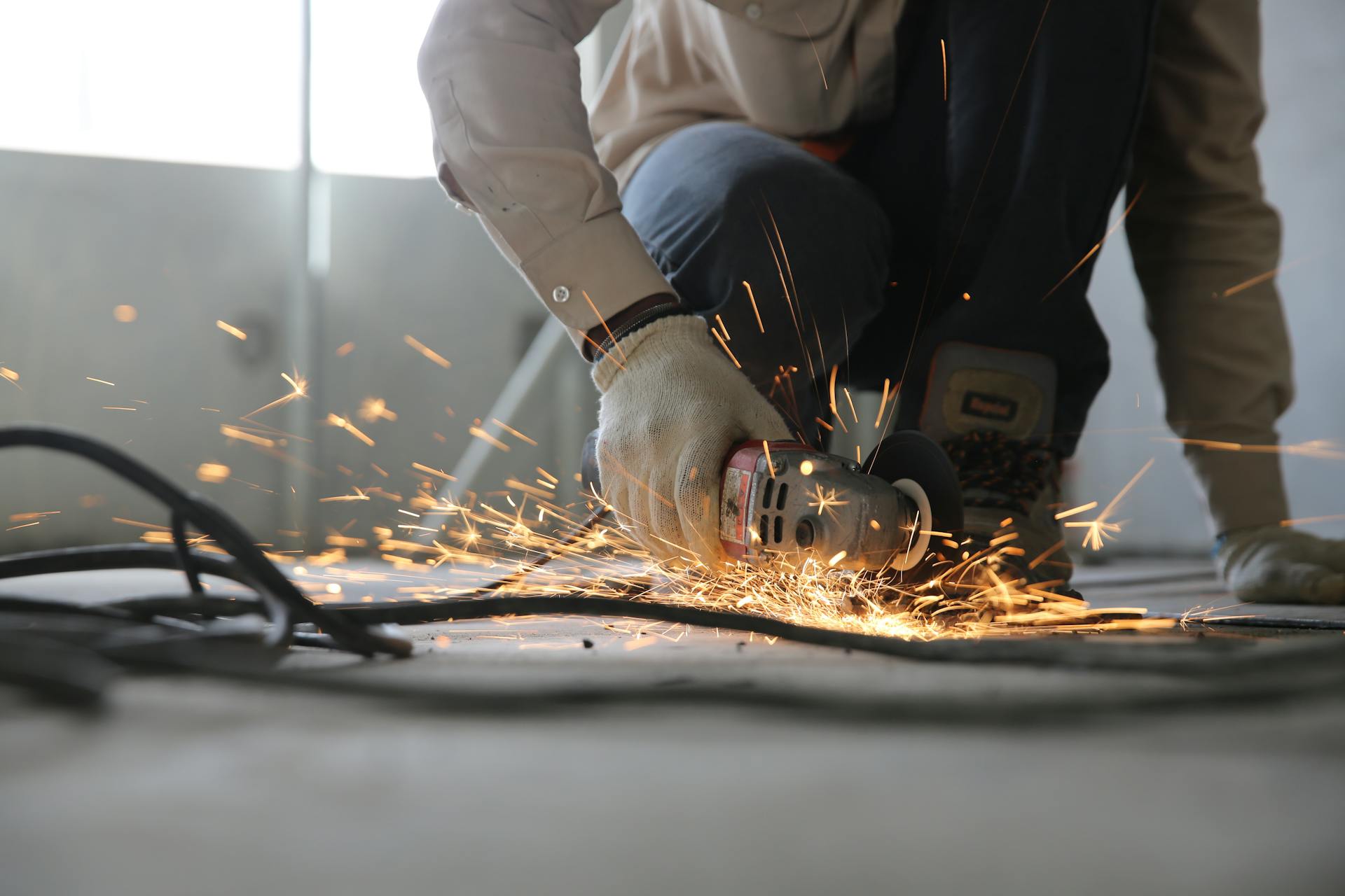 A man using a grinder on a plank of wood